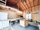 Interior workshop featuring plywood walls, a large ceiling fan, workbenches, storage cabinets, and barn door at 25640 State Road 70 E, Myakka City, FL 34251
