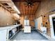 Interior workshop featuring plywood walls, a large ceiling fan, workbenches, storage cabinets, and barn door at 25640 State Road 70 E, Myakka City, FL 34251