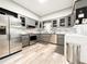 Well-lit kitchen boasts stainless steel appliances, granite countertops, gray cabinets, and a tile backsplash at 25640 State Road 70 E, Myakka City, FL 34251