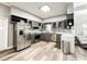 Well-lit kitchen boasts stainless steel appliances, granite countertops, gray cabinets, and a tile backsplash at 25640 State Road 70 E, Myakka City, FL 34251