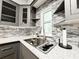 Close-up of a kitchen sink and counter featuring granite countertops, tile backsplash, and stainless steel appliances at 25640 State Road 70 E, Myakka City, FL 34251