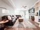 Large living room featuring built-in shelves, a fireplace, a ceiling fan, and a comfortable leather sofa with large area rug at 25640 State Road 70 E, Myakka City, FL 34251