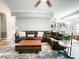 Open-concept living room with a large sectional sofa, modern lighting, fireplace, and access to the kitchen at 25640 State Road 70 E, Myakka City, FL 34251