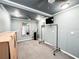 Bright, carpeted room with blue walls, modern lighting, mirror, TV and mobile clothing rack at 25640 State Road 70 E, Myakka City, FL 34251