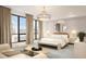 Bright bedroom features a modern chandelier, decorative mirror, and a large window with natural light at 33 S Palm Ave # 1501, Sarasota, FL 34236