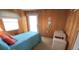 Bedroom featuring paneled walls, a window, a door, and a twin bed at 3333 26Th E Ave # 1145, Bradenton, FL 34208