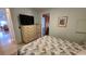 Cozy bedroom with a TV and patterned bedding next to a doorway and corner table at 3333 26Th E Ave # 1145, Bradenton, FL 34208