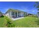 Wide view of backyard showing covered patio, manicured lawn and perimeter fence at 3419 74Th Avenue E Cir, Sarasota, FL 34243