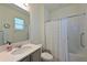 Bright bathroom features a shower with white shower curtain and a gray vanity with a white countertop at 3419 74Th Avenue E Cir, Sarasota, FL 34243
