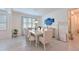 Bright dining room with modern chandelier, stylish furniture, and large window at 3419 74Th Avenue E Cir, Sarasota, FL 34243