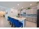 Modern kitchen with quartz countertops, stainless steel appliances, and stylish blue bar stools at 3419 74Th Avenue E Cir, Sarasota, FL 34243