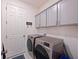 Convenient laundry room with cabinets for storage and stainless steel washer and dryer at 3419 74Th Avenue E Cir, Sarasota, FL 34243