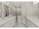 Well-lit bathroom with dual vanities, neutral tile and a glass enclosed shower at 4609 Deep Creek Ter, Parrish, FL 34219