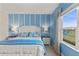 Bright bedroom with a blue accent wall, bedside lamps and a window view at 4609 Deep Creek Ter, Parrish, FL 34219