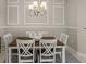Dining room with a wood table, white chairs, decorative wall trim, and a chandelier with ample natural light at 4609 Deep Creek Ter, Parrish, FL 34219