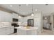 Modern kitchen featuring white cabinets, granite countertops, stainless steel appliances, and a decorative backsplash at 4609 Deep Creek Ter, Parrish, FL 34219