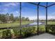 Scenic view of a lake from a screened in lanai with green landscaping at 4609 Deep Creek Ter, Parrish, FL 34219