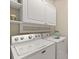 Laundry room with white cabinets and front load washer and dryer at 4609 Deep Creek Ter, Parrish, FL 34219