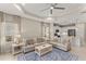 Open living area with a ceiling fan, two sofas, decorative area rug, and a view into the modern kitchen at 4609 Deep Creek Ter, Parrish, FL 34219