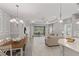 Bright, open-concept living area featuring dining, living, and kitchen spaces with neutral tile flooring and light decor at 4609 Deep Creek Ter, Parrish, FL 34219
