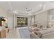 Spacious living room with large sliding doors leading to a screened lanai, featuring a ceiling fan and neutral tones at 4609 Deep Creek Ter, Parrish, FL 34219