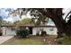 Charming single-story home featuring a textured exterior and a well-maintained front yard with mature trees at 4661 Linwood St, Sarasota, FL 34232