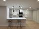 Modern kitchen with white cabinets, stainless steel appliances, quartz countertops, and bar seating at 4661 Linwood St, Sarasota, FL 34232