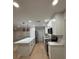 Modern kitchen featuring white cabinets, quartz countertops, a center island, and stainless steel appliances at 4661 Linwood St, Sarasota, FL 34232