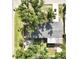 An aerial view displays the home's backyard patio, mature trees and driveway at 6031 11Th E St, Bradenton, FL 34203
