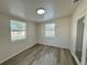 Bright bedroom with wood-look flooring, neutral paint, and two windows at 6031 11Th E St, Bradenton, FL 34203