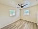 Bedroom featuring a ceiling fan, two bright windows, and wood-look floors at 6031 11Th E St, Bradenton, FL 34203