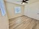 Bedroom with two bright windows, closet, modern ceiling fan, and wood-look floors at 6031 11Th E St, Bradenton, FL 34203