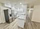 Beautiful kitchen featuring updated stainless steel appliances, white cabinets, and wood-look flooring at 6031 11Th E St, Bradenton, FL 34203