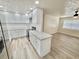 Bright kitchen featuring white cabinets, stainless steel appliances, an island, and wood-look floors at 6031 11Th E St, Bradenton, FL 34203