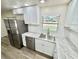 Well-lit kitchen features stainless steel appliances, white cabinets, granite countertops, and wood-look flooring at 6031 11Th E St, Bradenton, FL 34203