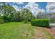 Grassy backyard featuring green foliage, a palm tree, and a view of the screened-in pool at 6644 Butlers Crest Dr, Bradenton, FL 34203