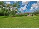 Sprawling green backyard with a tree and a view of the screened-in outdoor pool area at 6644 Butlers Crest Dr, Bradenton, FL 34203