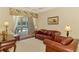 Bright living room featuring leather furniture and sliding doors to the outdoor pool at 6644 Butlers Crest Dr, Bradenton, FL 34203
