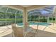 Screened-in pool and hot tub area with a view of the dining table on the covered patio at 6644 Butlers Crest Dr, Bradenton, FL 34203