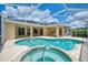 Beautiful outdoor pool and hot tub with a screened-in lanai and tan home exterior at 6644 Butlers Crest Dr, Bradenton, FL 34203