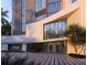 Elegant condo building entrance with a porte-cochere, lush landscaping, and modern architectural details at 688 Golden Gate Point # 202, Sarasota, FL 34236