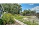 The backyard has lush landscaping and a pathway, creating a peaceful oasis and natural beauty at 809 40Th St, Sarasota, FL 34234