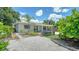 Charming home featuring a gravel yard, patio furniture, and tasteful landscaping under a sunny, partly cloudy sky at 809 40Th St, Sarasota, FL 34234