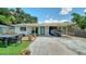 Charming home featuring stone walkway, small yard, covered parking area, and a light turquoise front door at 809 40Th St, Sarasota, FL 34234