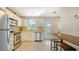 Bright kitchen with stainless steel appliances, white cabinetry, and a bar-style dining area at 809 40Th St, Sarasota, FL 34234