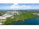 Aerial view showcases a waterfront property nestled among lush greenery and a serene bay at 9403 9Th Nw Ave, Bradenton, FL 34209