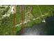 Aerial view of a waterfront property shows a pier, lush green, and boundaries at 9403 9Th Nw Ave, Bradenton, FL 34209
