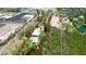 Stunning aerial view of property with waterfront access, lush greenery, and adjacent tennis courts at 9403 9Th Nw Ave, Bradenton, FL 34209
