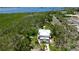Overhead image showing a two-story home surrounded by lush trees, a boat dock and tropical vegetation at 9403 9Th Nw Ave, Bradenton, FL 34209