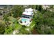 Aerial view of backyard with a sparkling pool, waterside dock, and lush surrounding vegetation at 9403 9Th Nw Ave, Bradenton, FL 34209